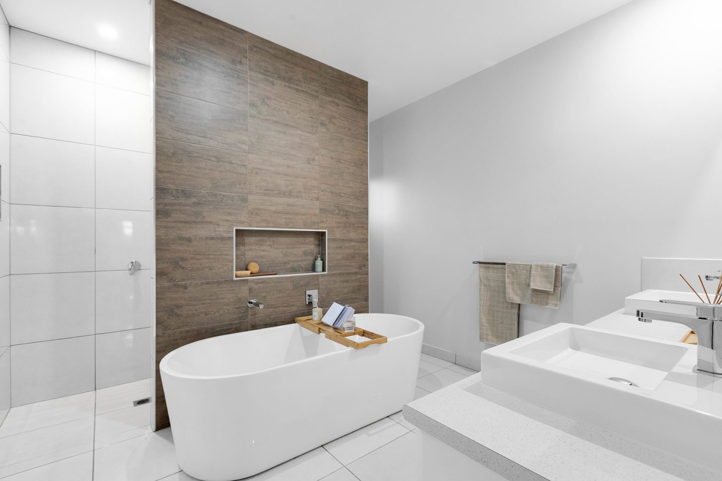 Ensuite with a freestanding bath, twin vanity and tiled feature wall